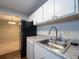 Bright kitchen featuring stainless steel sink, white cabinets, and a view to adjacent room at 408 Smokerise Se Cir, Marietta, GA 30067