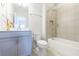 Bathroom with blue vanity, white toilet, and a tiled shower-tub combo, creating a calm spa-like space at 4405 Croftshire Pl, Cumming, GA 30040