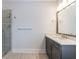 Bathroom featuring gray vanity with white countertop, large mirror, and glass enclosed shower at 4405 Croftshire Pl, Cumming, GA 30040