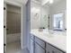 Bright bathroom features grey vanity with white countertop and decorative mirror at 4405 Croftshire Pl, Cumming, GA 30040