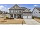 Charming two-story brick home featuring a welcoming front porch, two-car garage, and beautifully landscaped front yard at 4405 Croftshire Pl, Cumming, GA 30040