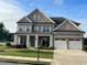 Beautiful brick home with manicured lawn, three car garage and inviting covered porch at 4405 Croftshire Pl, Cumming, GA 30040