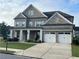 Lovely brick home boasts a three-car garage and covered front porch at 4405 Croftshire Pl, Cumming, GA 30040