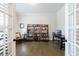 Home office space featuring hardwood floors, a desk, and built-in bookshelves at 4405 Croftshire Pl, Cumming, GA 30040