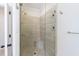 Walk-in shower featuring glass enclosure, tiled walls, and a built-in seat at 4405 Croftshire Pl, Cumming, GA 30040