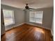 A bright bedroom with hardwood floors, windows, and a ceiling fan at 675 Sowell Rd, Mcdonough, GA 30252