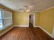 Empty bedroom features yellow walls, hardwood flooring, a window, and a ceiling fan at 675 Sowell Rd, Mcdonough, GA 30252