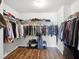 Organized walk-in closet featuring hardwood floors, shelves, and hanging rods at 7937 Habanera Ln, Lithonia, GA 30058