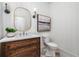 Charming powder room featuring wood vanity, marble countertop, and stylish wall decor at 1304 Marietta Country Club Nw Dr, Kennesaw, GA 30152