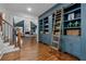Elegant hallway with custom built-in blue bookshelves and a rolling ladder at 1304 Marietta Country Club Nw Dr, Kennesaw, GA 30152