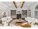 Spacious living room with a cozy fireplace, built-in bookshelves, wood beams and neutral decor at 1304 Marietta Country Club Nw Dr, Kennesaw, GA 30152