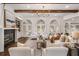 Bright living room featuring a fireplace, wood beams, arched windows, and comfortable seating at 1304 Marietta Country Club Nw Dr, Kennesaw, GA 30152