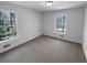 Bright bedroom with neutral carpet and two windows providing natural light and views of the surrounding landscape at 160 Benjamin Cir, Fayetteville, GA 30214