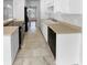 Well-lit kitchen featuring tile flooring, white cabinetry, and modern appliances, with an open view to the adjacent living area at 160 Benjamin Cir, Fayetteville, GA 30214