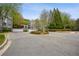 Welcoming condo community entrance with a roundabout, gate, and attractive landscaping at 4100 Paces Se Walk # 2309, Atlanta, GA 30339