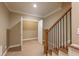 Hallway showing staircase with wooden railings, door to a closet, and carpeted flooring at 6186 Talmadge Nw Run, Acworth, GA 30101