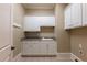Practical laundry room offers plentiful of storage space with modern cabinetry and granite counters at 6186 Talmadge Nw Run, Acworth, GA 30101