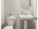 Well-lit powder room featuring a pedestal sink and modern fixtures at 709 Bismark Ne Rd, Atlanta, GA 30324