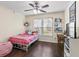 Cozy bedroom with wood floors, a ceiling fan, a window, and a bed adorned with colorful pillows and blankets at 4829 Thicket Nw Path, Acworth, GA 30102