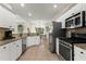 Well-lit kitchen featuring white cabinets, granite countertops, stainless steel appliances, and backyard views at 4829 Thicket Nw Path, Acworth, GA 30102
