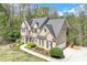 An elevated view of a brick home with siding, mature trees, and a long driveway at 2830 Willow Hill Ct, Cumming, GA 30040
