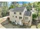 Rear exterior view of the home with a large deck, a walk out basement, and lush, wooded surroundings at 2830 Willow Hill Ct, Cumming, GA 30040
