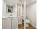 Basement bathroom features a modern vanity, white toilet, and wood-look accent wall at 2905 Dale Creek Drive Nw, Atlanta, GA 30318