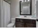 Clean bathroom featuring a dark wood vanity, a mirror, and a shower with white shower curtain at 433 Cranleigh Se Rdg, Smyrna, GA 30080