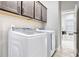 Convenient laundry room equipped with modern machines and additional storage cabinets at 433 Cranleigh Se Rdg, Smyrna, GA 30080