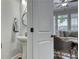 Clean powder room features a pedestal sink, round mirror, and neutral decor, offering a stylish and functional space at 433 Cranleigh Se Rdg, Smyrna, GA 30080