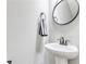 Clean powder room features a pedestal sink, round mirror, and neutral decor, offering a stylish and functional space at 433 Cranleigh Se Rdg, Smyrna, GA 30080