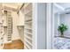 Spacious walk-in closet boasts custom shelving, providing ample storage space, next to an office area at 433 Cranleigh Se Rdg, Smyrna, GA 30080