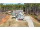 Aerial view of a home with a spacious driveway, lush landscaping, and a private backyard with a pool at 7500 Gillespie Pl, Douglasville, GA 30135