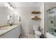 Bathroom with double sinks, granite countertop, framed mirror, toilet, and a glass-enclosed shower at 7500 Gillespie Pl, Douglasville, GA 30135