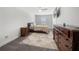 Comfortable bedroom with a queen bed, wood dresser, ceiling fan and soft rug on a carpeted floor at 7500 Gillespie Pl, Douglasville, GA 30135