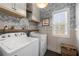 Charming laundry room with stylish wallpaper, washer, dryer, and natural light at 7500 Gillespie Pl, Douglasville, GA 30135