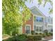 Two-story townhouse with brick accents, gray siding, and lush green trees at 9155 Nesbit Ferry Rd # 65, Alpharetta, GA 30022