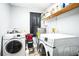 Functional laundry area with modern washer and dryer, ample shelving for storage and utility at 265 Winding Stream Trl, Hampton, GA 30228