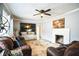 Cozy living room with a ceiling fan, fireplace, and comfortable brown leather sofas at 265 Winding Stream Trl, Hampton, GA 30228