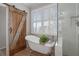 A bathroom with a claw foot tub next to a rustic sliding barn door at 997 Woodbury Rd, Canton, GA 30114