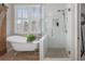 A bathroom featuring a soaking tub and walk in shower with clear glass door at 997 Woodbury Rd, Canton, GA 30114