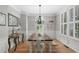 Elegant dining room with hardwood floors, decorative chandelier, wainscoting and large window at 997 Woodbury Rd, Canton, GA 30114