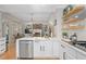 Open kitchen with stainless steel appliances, white cabinets, and a view into the living area at 997 Woodbury Rd, Canton, GA 30114