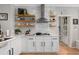 Bright kitchen with white cabinets, open shelving, stainless range hood, and hardwood floors at 997 Woodbury Rd, Canton, GA 30114