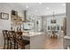 Bright kitchen with white cabinets, island with seating, stainless hood, and eat-in dining area at 997 Woodbury Rd, Canton, GA 30114