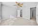 Bright bedroom with carpet, ceiling fan, and a door leading to an ensuite bathroom at 1721 Telfair Chase Way, Lawrenceville, GA 30043