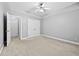 Bedroom featuring neutral walls and carpet, a tray ceiling with a ceiling fan, and plenty of storage at 1721 Telfair Chase Way, Lawrenceville, GA 30043