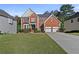 Beautiful two-story brick home features a manicured lawn, a two-car garage, and lush, green landscaping at 1721 Telfair Chase Way, Lawrenceville, GA 30043