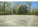 Outdoor tennis court surrounded by trees, offering a recreational amenity for residents at 2112 Palmyra Dr, Marietta, GA 30067