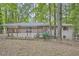 Exterior view showcasing a brick home with a deck, nestled among lush greenery at 2184 Pemberton Sw Rd, Atlanta, GA 30331